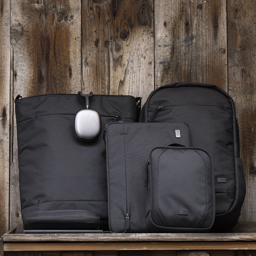 The Case Logic Invigo bags sit lined up against a wooden wall.