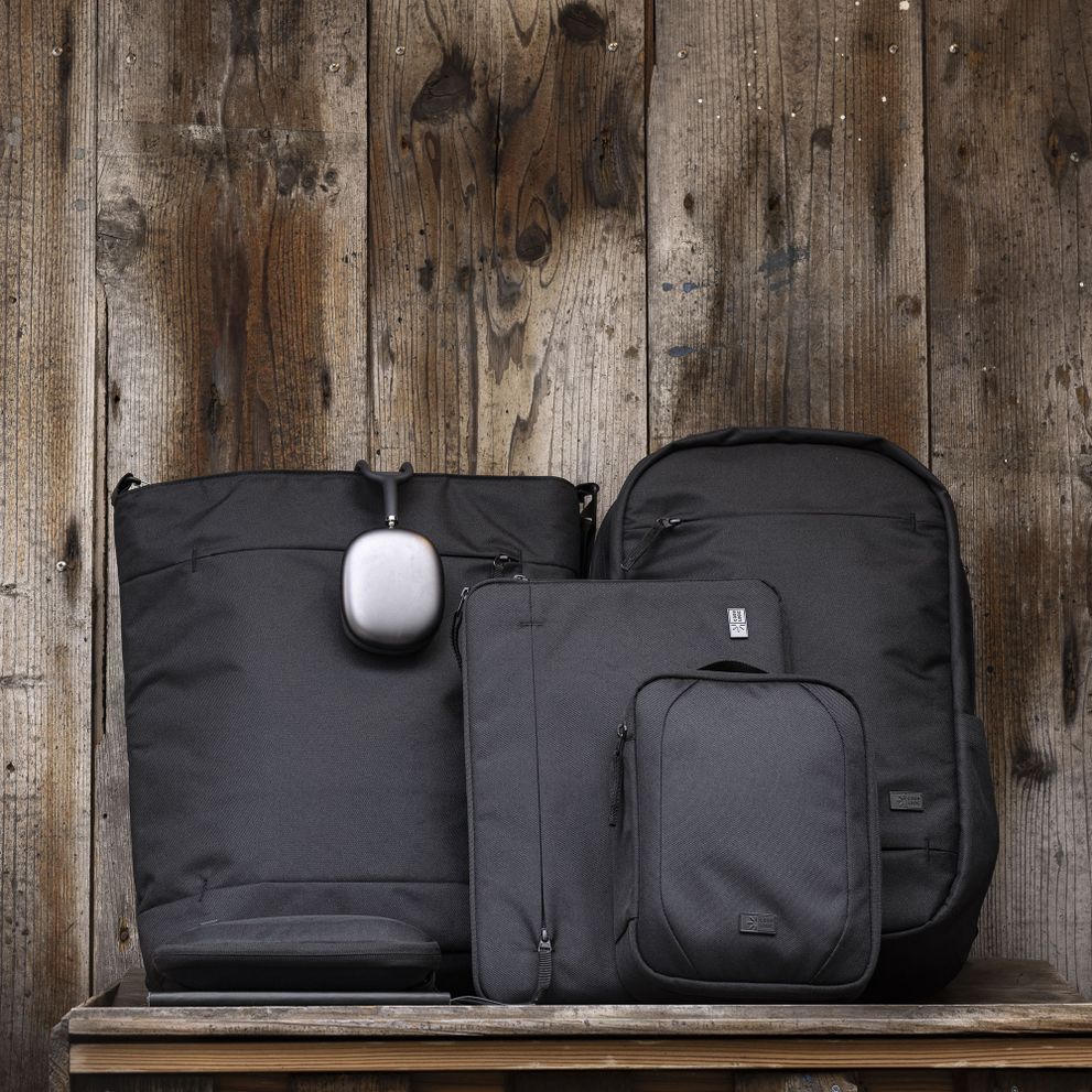 The Case Logic Invigo bags sit lined up against a wooden wall.