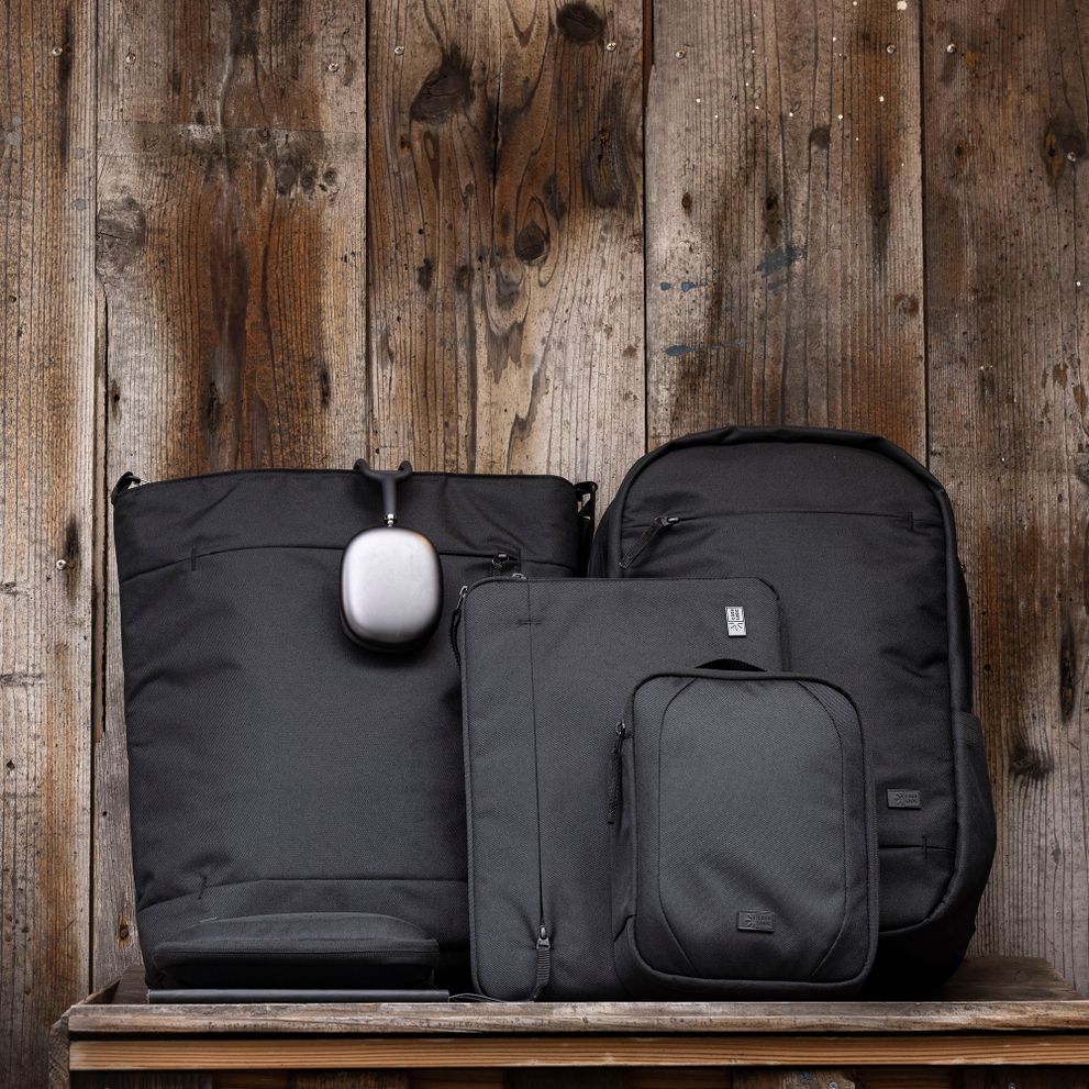 The Case Logic Invigo bags sit lined up against a wooden wall.