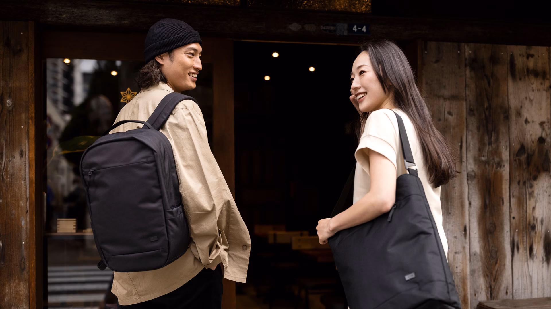 A man and woman with Case Logic bags stand outside a door.